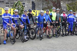 14 Radfahrer mit Trikots des Radsportverein Edelweiß Bliesransbach stehen vor dem Brunnen auf dem Dorfplatz in Bliesransbach